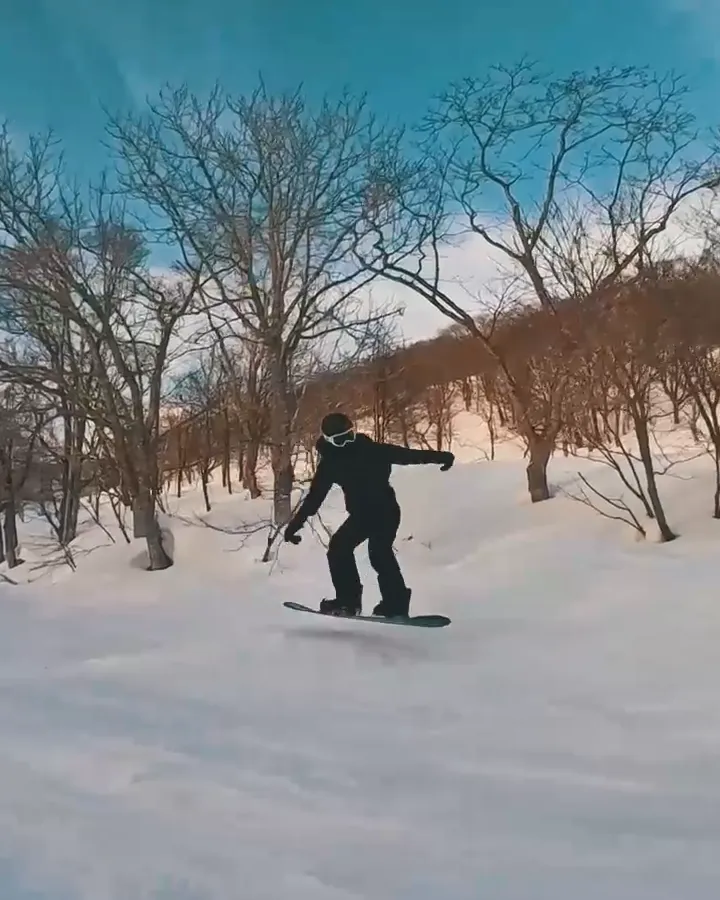 Coaching pause on a snowboarder riding a groomed run, with an arrow to the rider's head